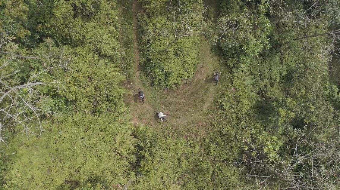 Three riders in a looping corner, seen from the air